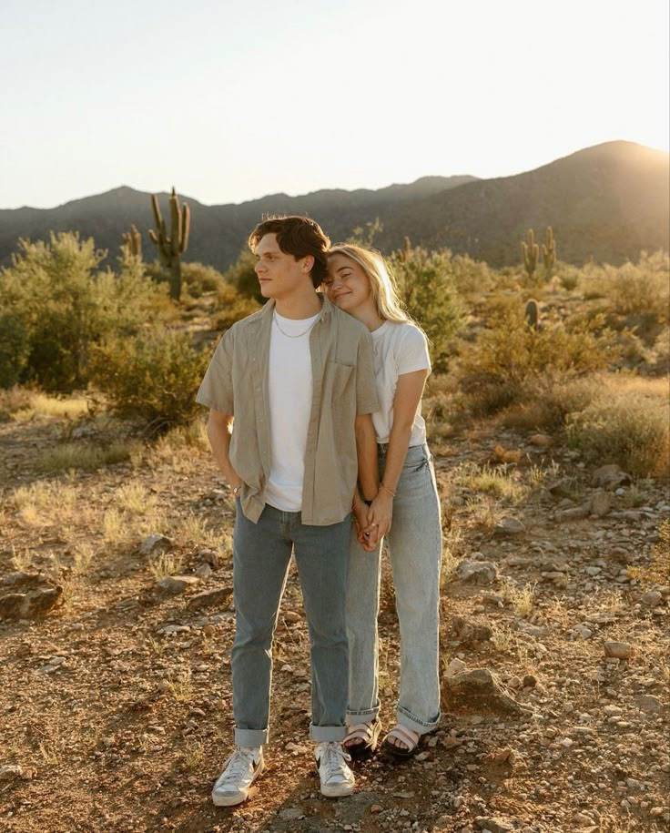 a man and woman standing in the desert