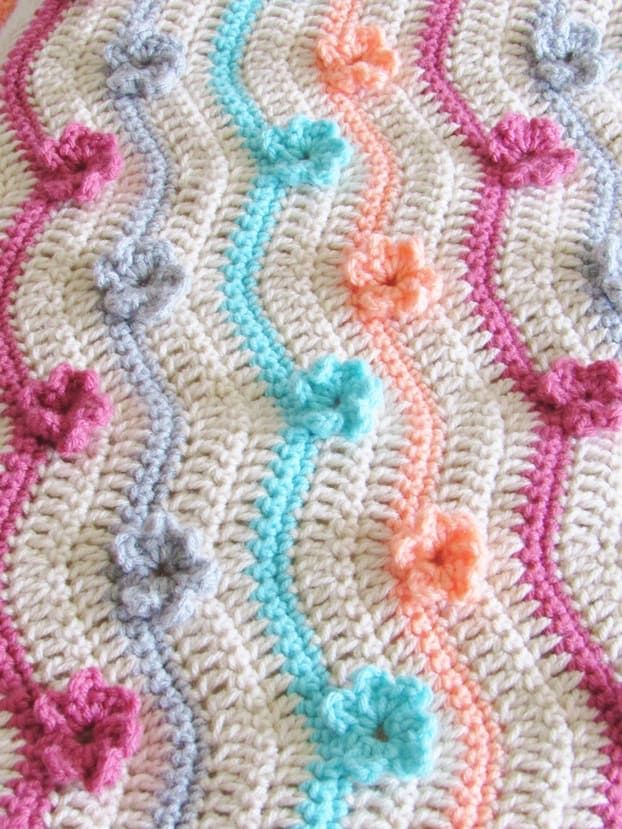 a crocheted blanket with hearts on it