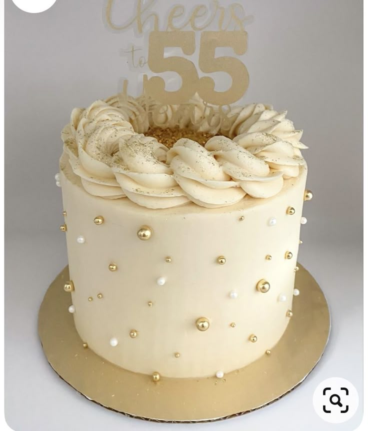 a cake with white frosting and gold sprinkles