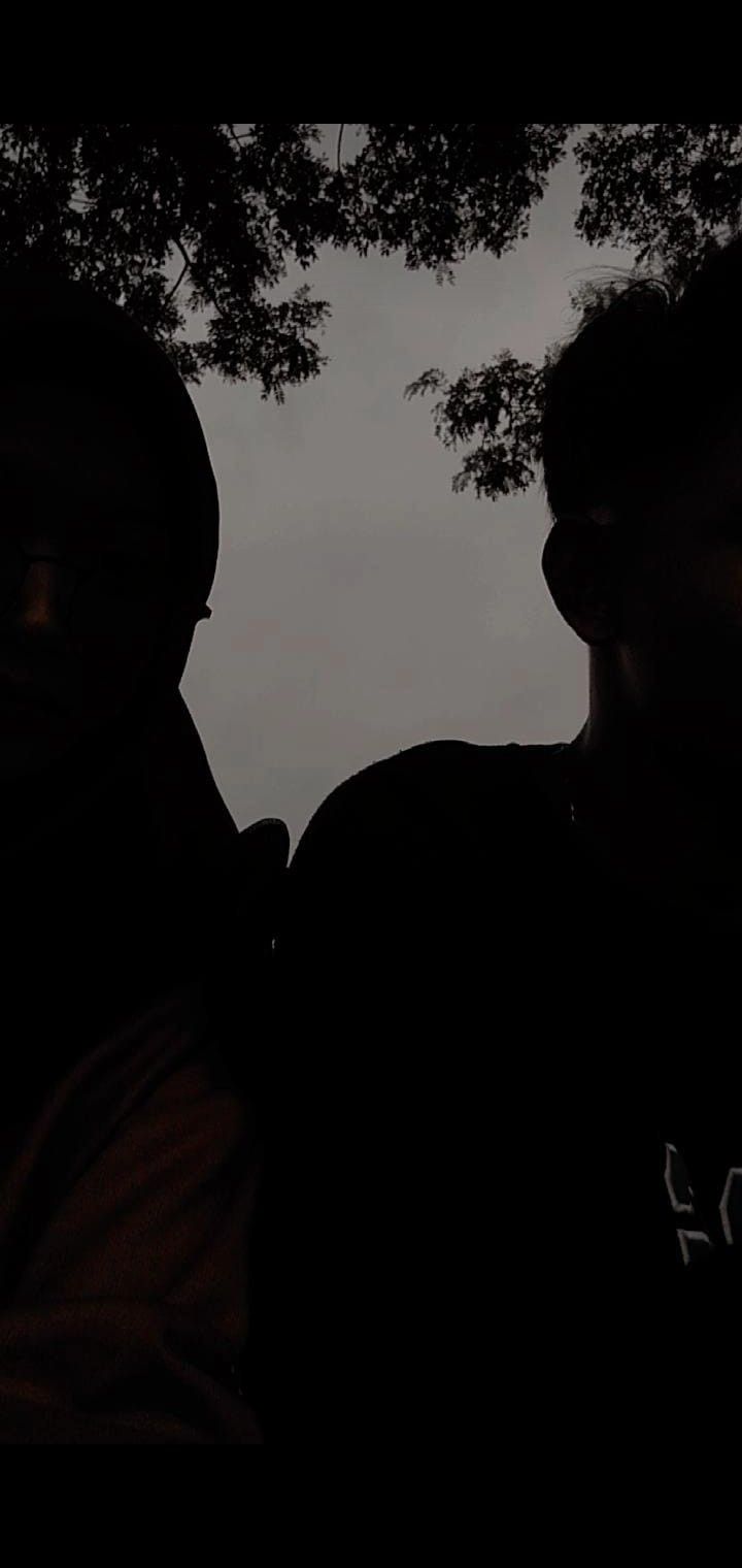 two men sitting next to each other in the dark