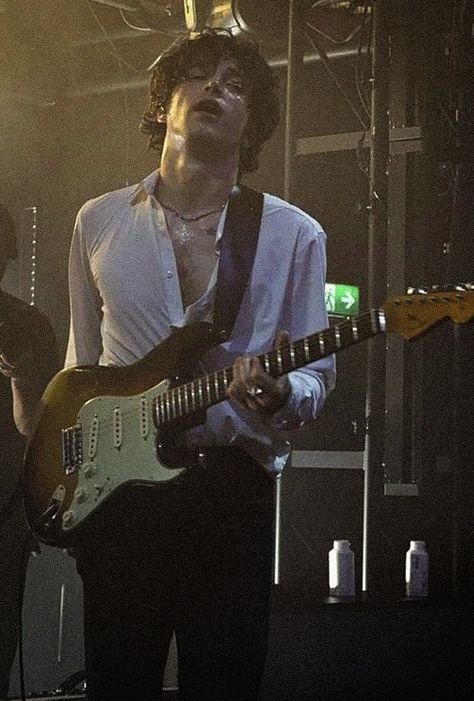 a man playing an electric guitar on stage