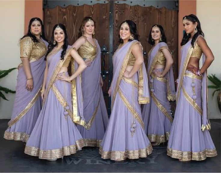 four beautiful women in sari posing for the camera