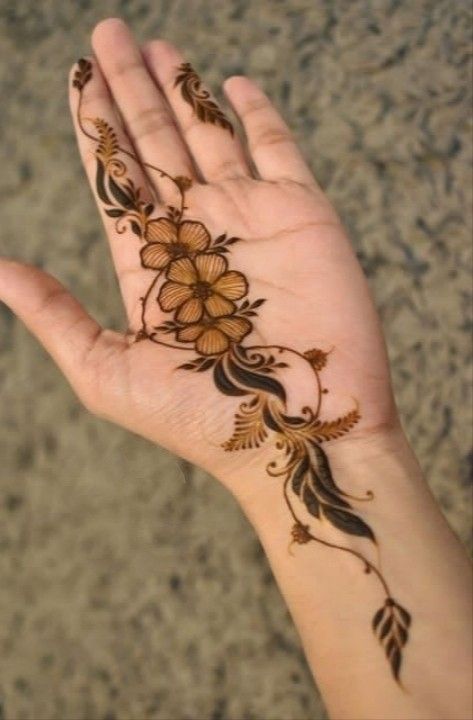 a person's hand with henna tattoos on it and flowers on the palm