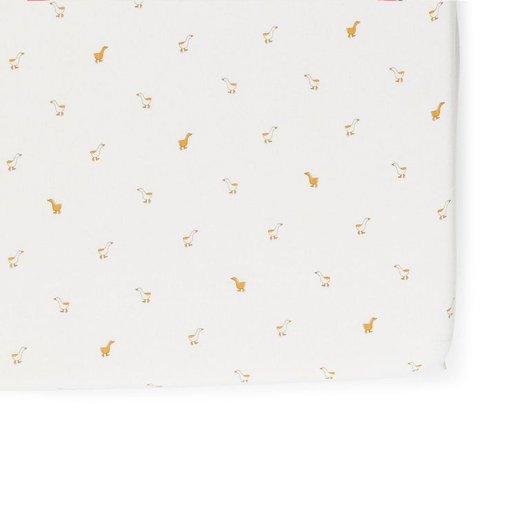 a white sheet with gold deers on it and pink trim around the bottom half