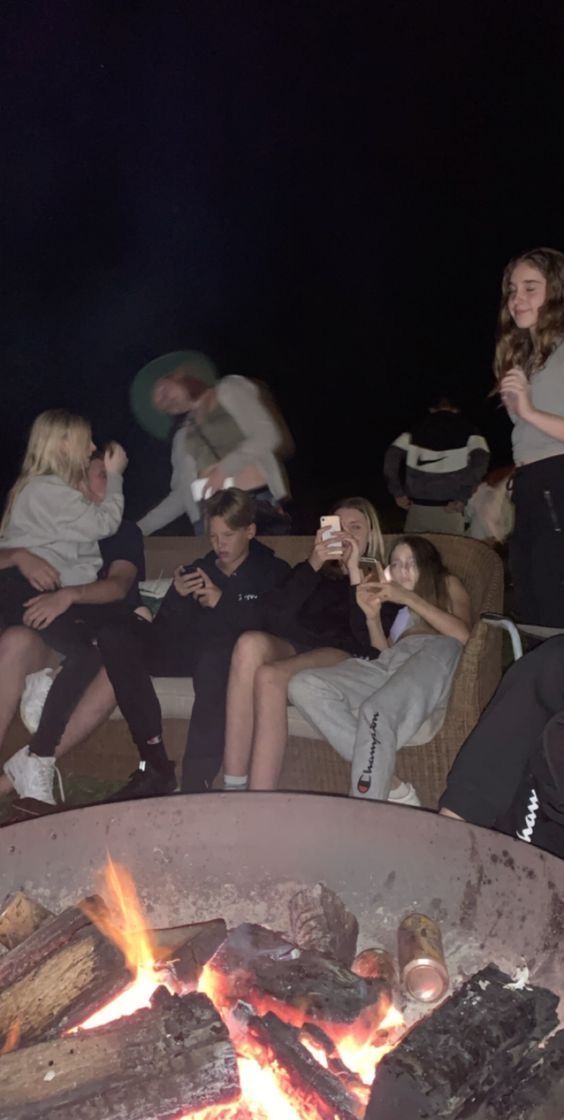 a group of people sitting around a fire pit