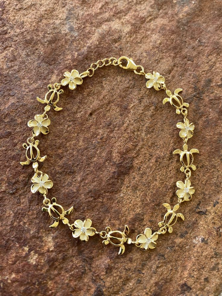 "8MM PLUMERIA & TURTLE GOLD PLATED STERLING SILVER BRACELET This genuine yellow gold plated sterling silver bracelet features the Hawaiian Plumeria Flower and Hawaiian Sea Turtle. Plumeria, in Hawaiian culture symbolizes beauty, charm, grace, and new beginnings, or re-birth. It is one of the most popular flowers on the Hawaiian Islands and widely used in lei making and jewelry designs. The Hawaiian Sea Turtle, or \"Honu,\" symbolizes good luck, endurance, and long life. They are also known as \" Island Girl Jewelry, Hibiscus Flower Jewelry, Plumeria Accessories, Plumeria Jewelry, Cute Gold Jewelry, Gold Flower Jewelry, Good Bracelet, Cultural Jewelry, Gold Flower Bracelet