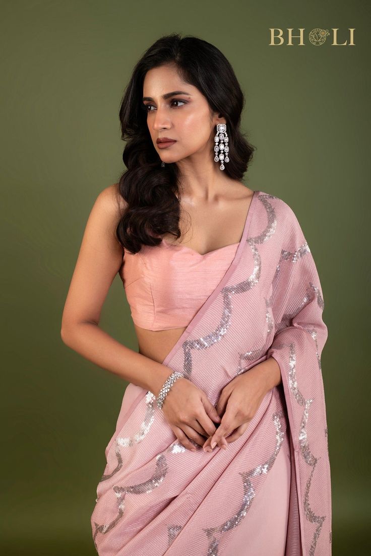 Expertly crafted with high quality Georgette fabric, this partywear saree is designed to make a statement. The elegant pink color and delicate sequin embellishments add a touch of glam to any occasion. Shine bright while feeling comfortable and confident in this must-have saree. Pink Cutdana Pre-draped Saree For Party, Designer Pink Pre-draped Saree With Zari Work, Semi-stitched Dola Silk Pre-draped Saree For Party, Fitted Tissue Silk Saree With Sequins, Festive Tissue Silk Saree With Sequins, Glamorous Pre-draped Saree With Cutdana For Party, Designer Pink Georgette Blouse, Party Wear Blouse With Sheer Dupatta, Pink Party Wear Pre-draped Saree With Mirror Work