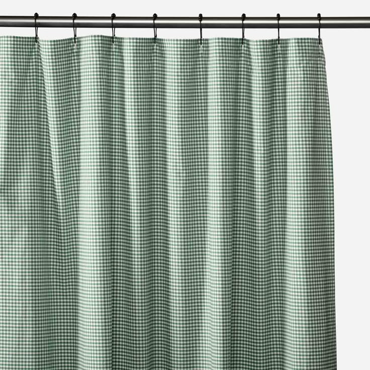 a green and white checkered shower curtain hanging on a metal rod with black hardware