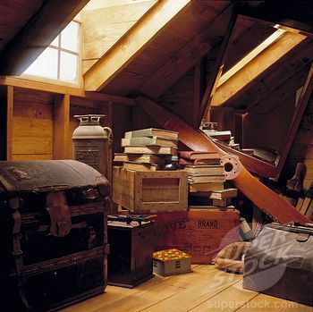 an attic filled with lots of old trunks and boxes on top of a wooden floor