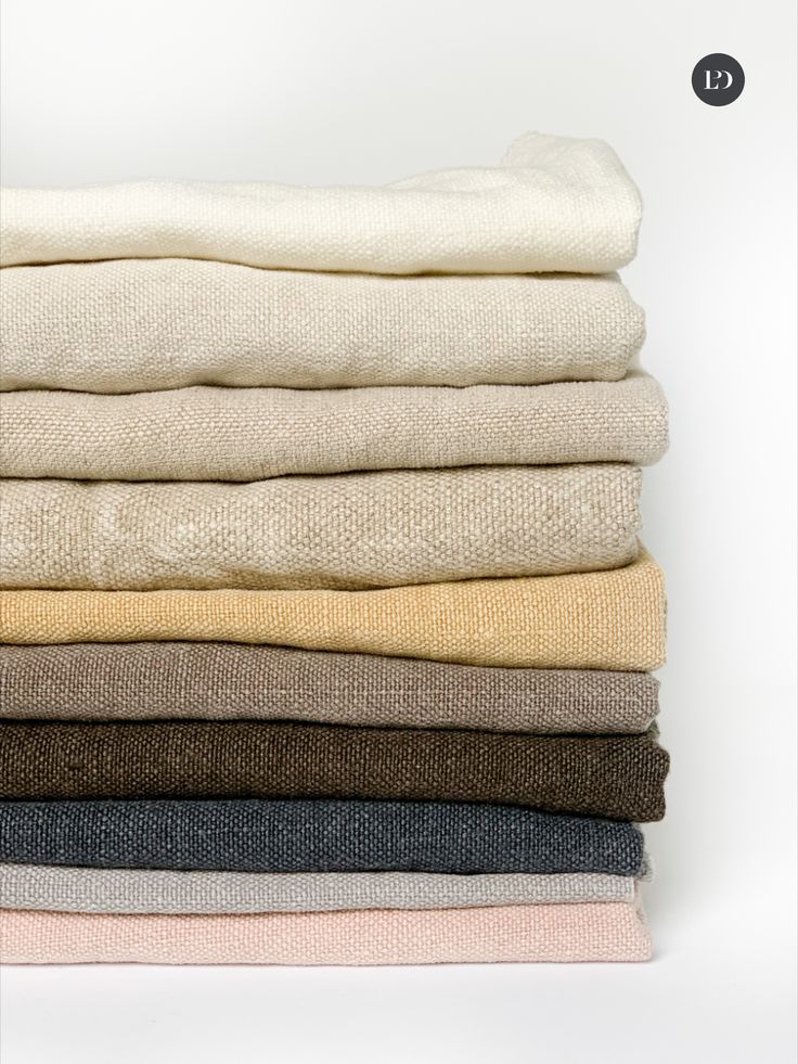 a stack of folded linens sitting on top of each other in different colors and sizes