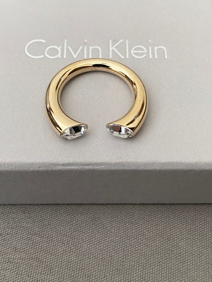 Calvin Klein Brilliant This Calvin Klein ring is very gorgeous on the fingers.    The clear stone makes it stand out. Calvin Klein embossed on the ring. Open ended ring  Comes with box and pouch. Modern Crystal Open Ring With Vs Clarity, Luxury Crystal Open Ring, Modern Crystal Open Ring For Anniversary, Modern Open Crystal Ring For Anniversary, Luxury Open Crystal Ring, Calvin Klein Accessories, Modern Open Crystal Ring For Formal Occasions, Modern Open Ring Jewelry With Vs Clarity, Modern Open Crystal Ring For Wedding