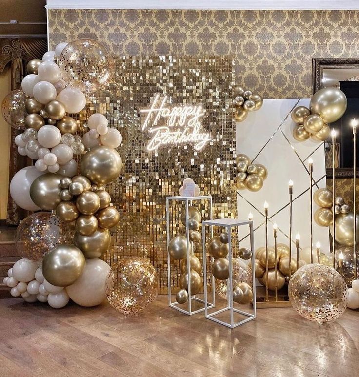 a room filled with lots of gold and white balloons