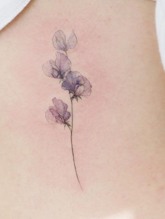 Watercolor Flower Tattoos: A Visual Guide Sweet Pea Tattoo Watercolor, Watercolor Violets Tattoo, Violet Tattoo Watercolor, Small Colored Flower Tattoos, Sweet Violet Tattoo, Violet Flower Tattoo Watercolor, Small Watercolour Tattoos, Translucent Flower Tattoo, Watercolor Tattoo Style