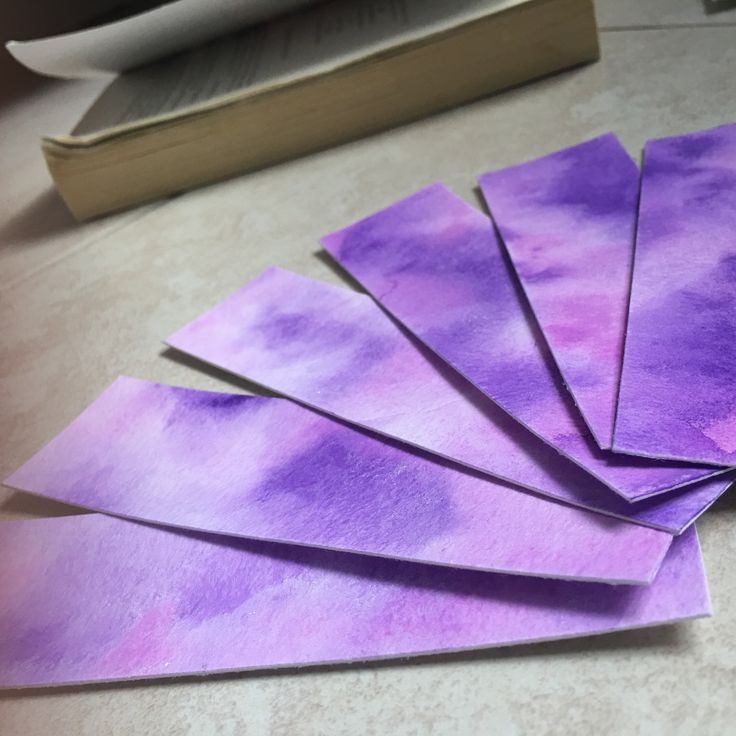 five pieces of purple paper sitting on top of a table