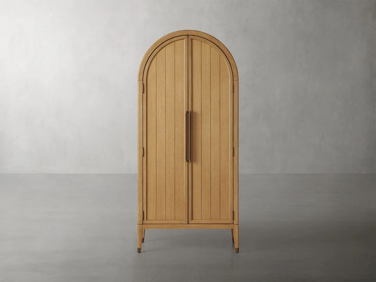 an arch shaped wooden cabinet in the middle of a room with concrete flooring and walls