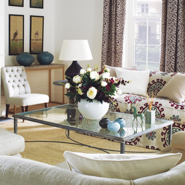 a living room with couches, chairs and a fire place in front of a window