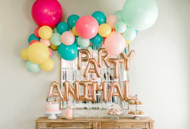 a party table with balloons, cake and confetti on the sideboard that says party ancetia