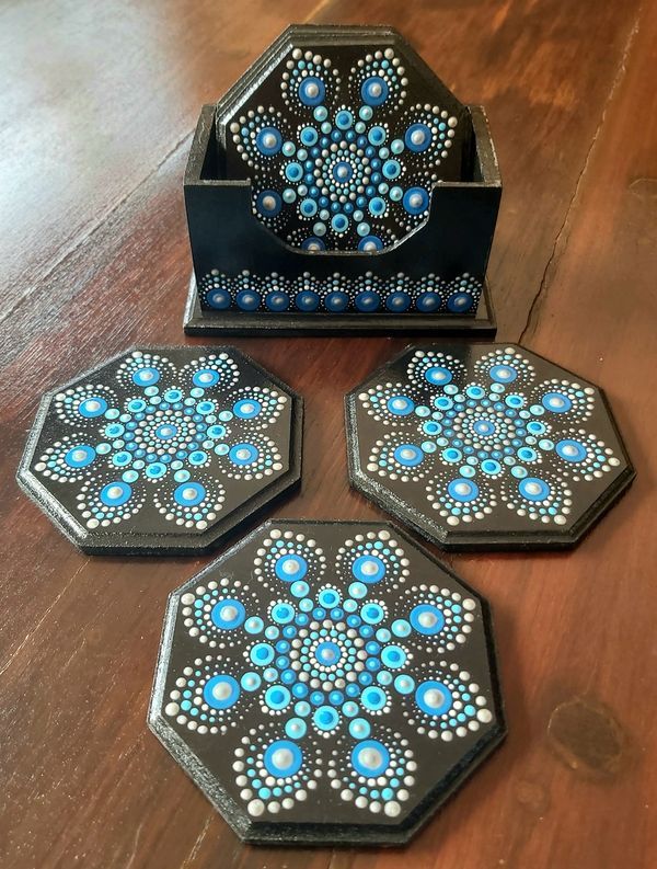 three blue and black coasters sitting on top of a wooden table