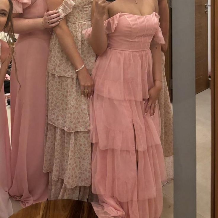 three women in pink dresses taking a selfie