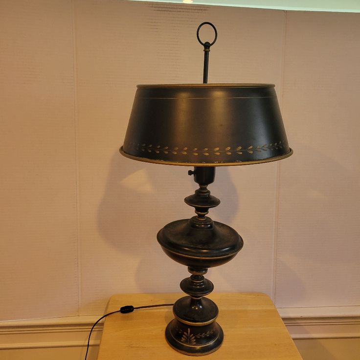 a lamp sitting on top of a wooden table next to a white wall and floor