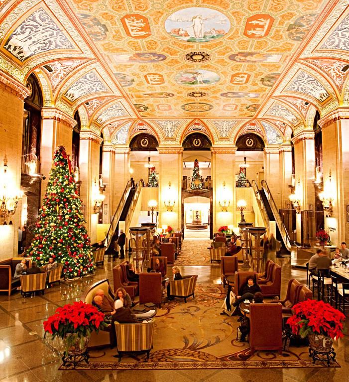 the lobby is decorated for christmas with decorations on the ceiling and chandeliers hanging from the ceiling