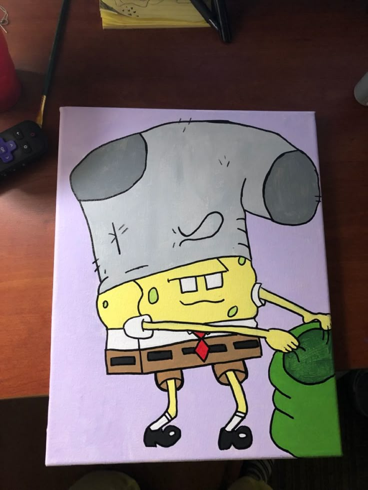 a drawing of a spongebob holding a green bag on a wooden table next to a remote control