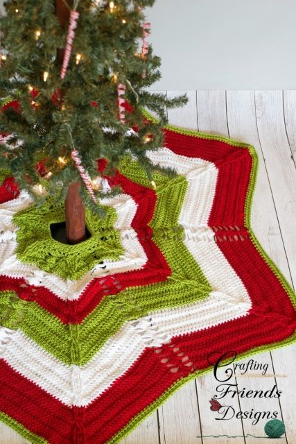 a crocheted christmas tree skirt is on the floor next to a small fir tree