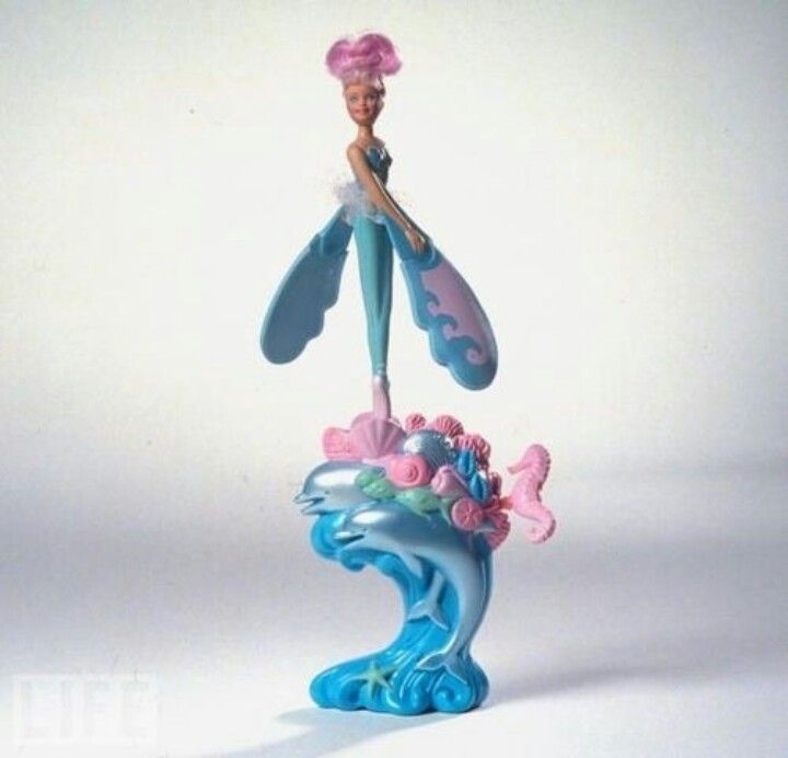 there is a figurine that looks like the little mermaid on top of a wave