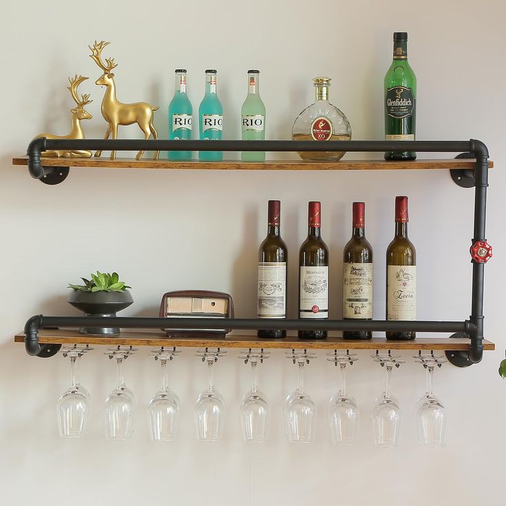 several wine glasses and bottles on a shelf