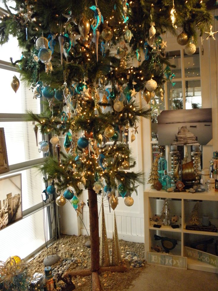 a christmas tree with ornaments on it in a room filled with other items and decorations