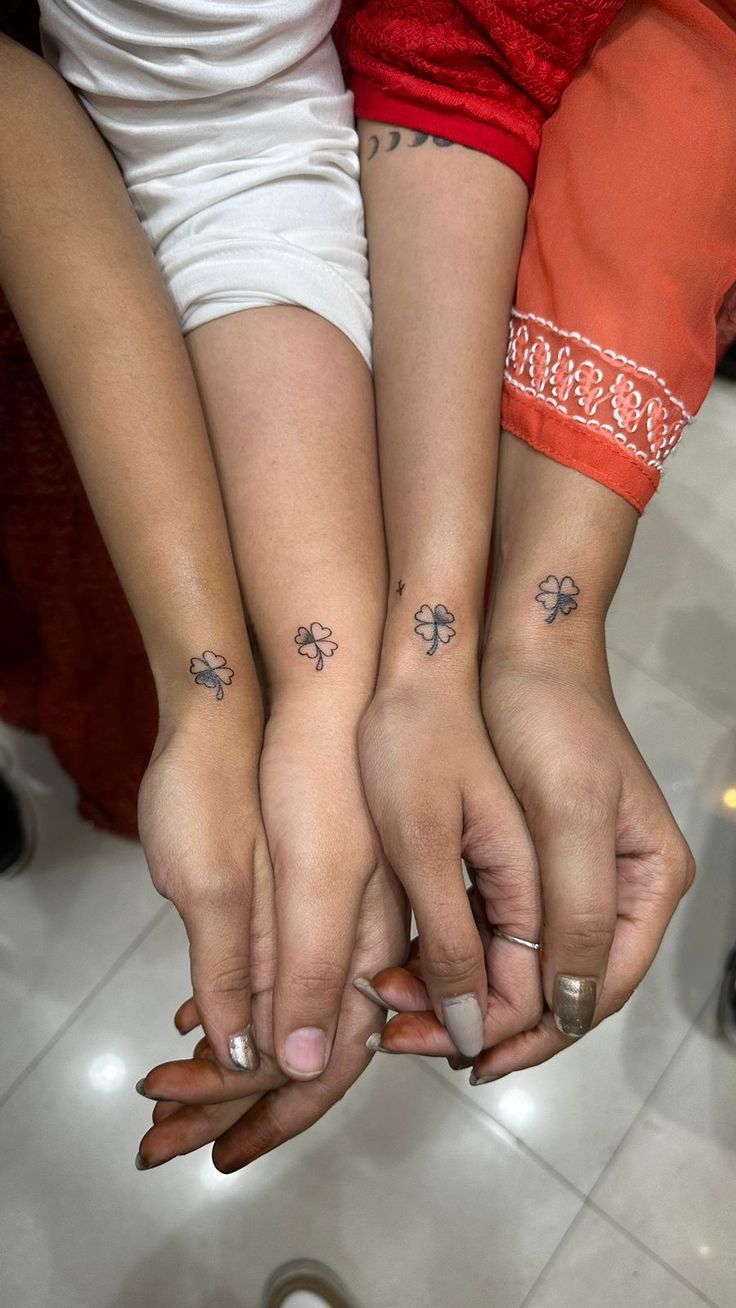 two girls with matching tattoos on their hands are holding each other's hand together