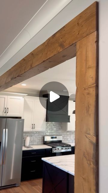 an open kitchen with stainless steel appliances and wood beams