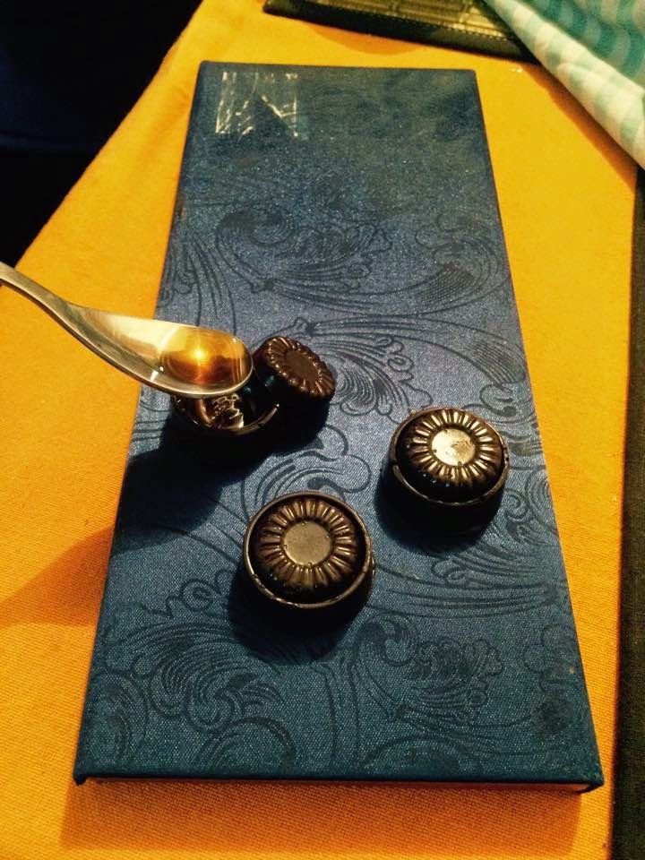 a spoon is sitting on top of a blue place mat that has three buttons attached to it