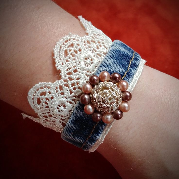 a close up of a person's arm wearing a bracelet with pearls and beads