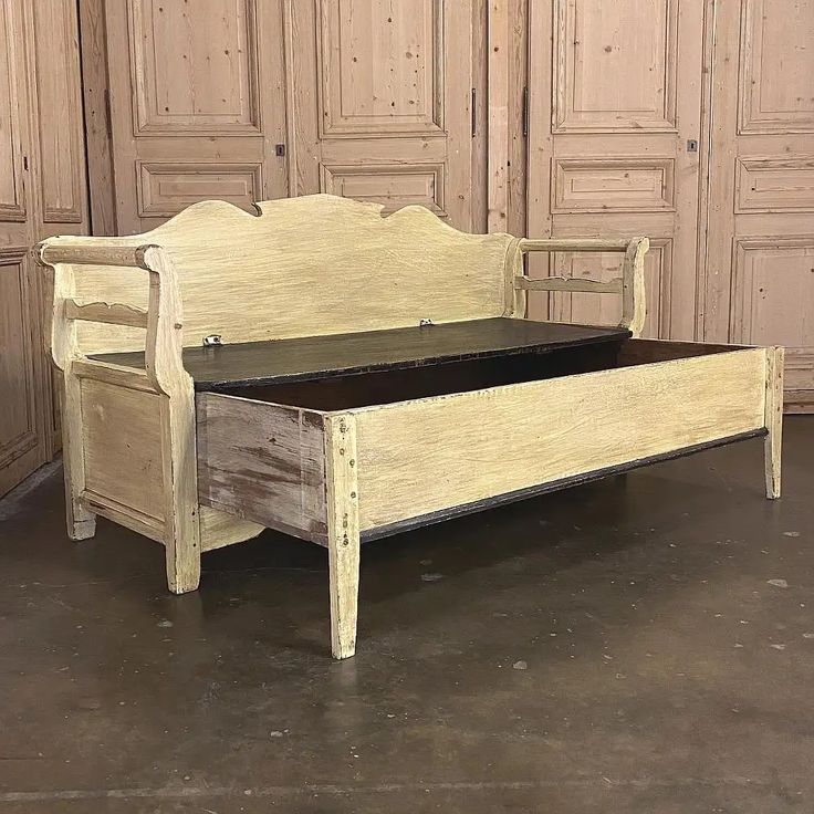 an old wooden bed frame and foot board in a room with wood paneled doors