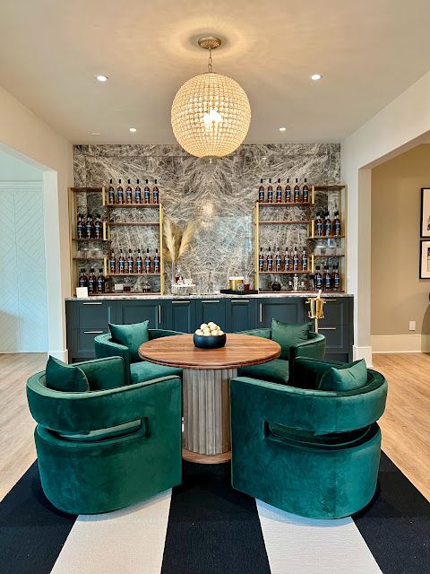 a living room with green chairs and a round table in the center of the room