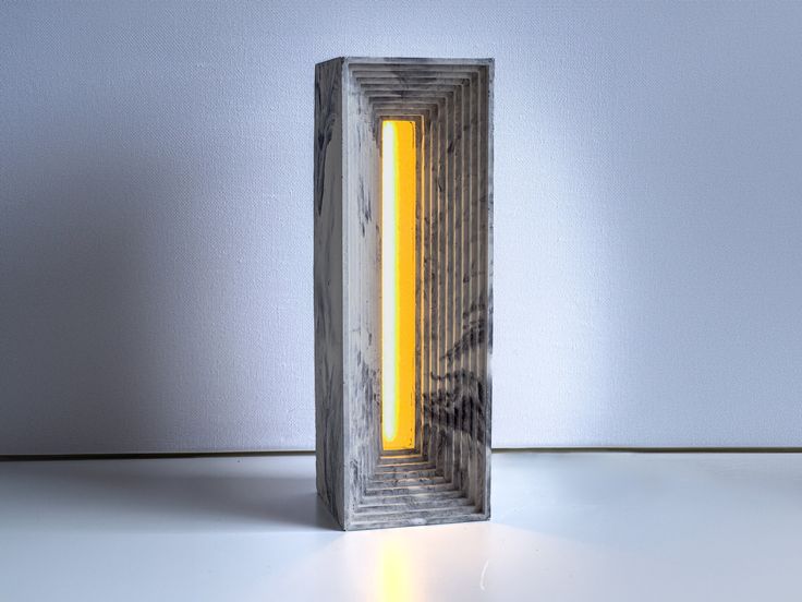 a light that is inside of a wooden box on the floor in front of a wall