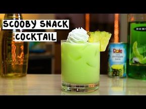 there is a green cocktail with whipped cream on top