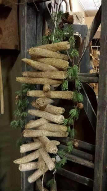 a bunch of bread hanging from the side of a wooden structure with pine cones on it