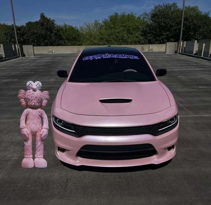 a pink car with a large teddy bear next to it