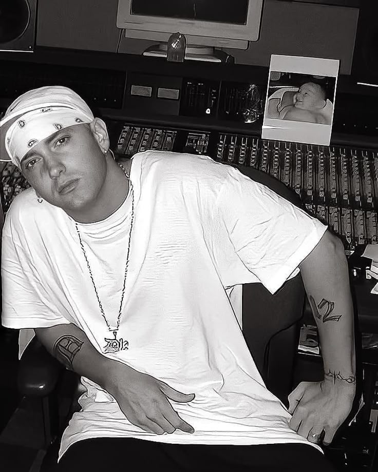 a young man sitting in front of a mixing desk with headphones on his ears