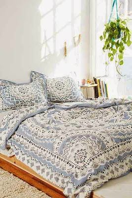 a bed with blue and white bedspread on top of it