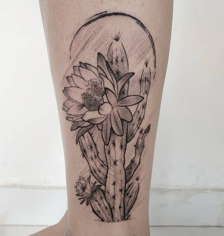 a cactus and flower tattoo on the leg