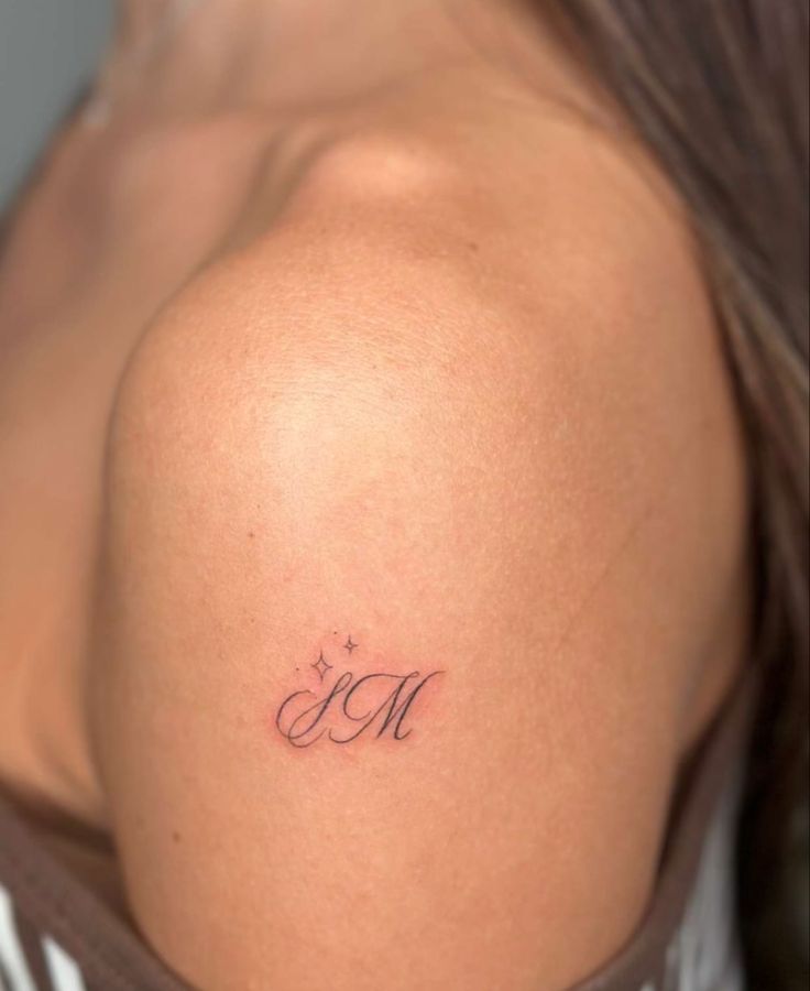 a woman with a small tattoo on her back shoulder and the word mom written in cursive writing