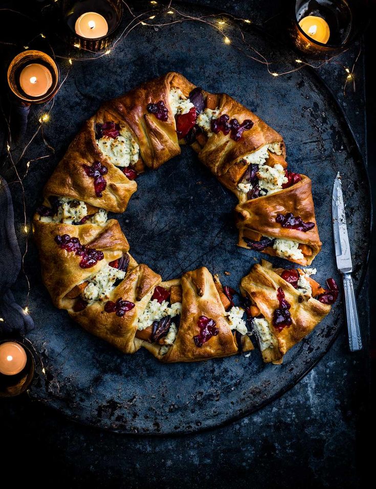 a large pastry on a plate with candles around it