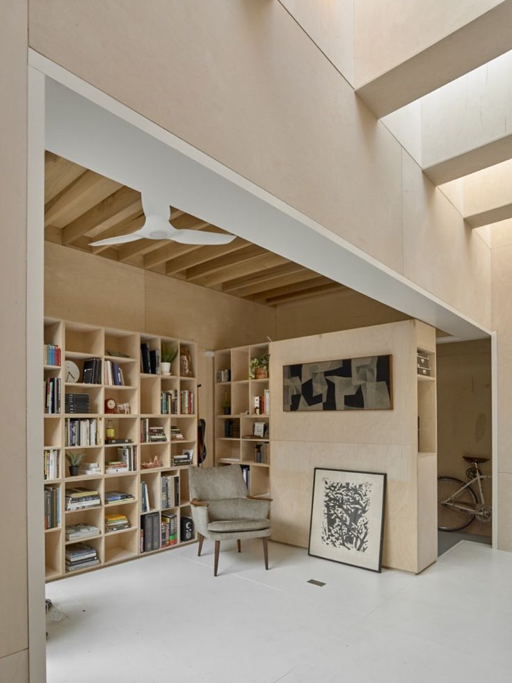 a room with bookshelves, chairs and pictures on the wall in it's center