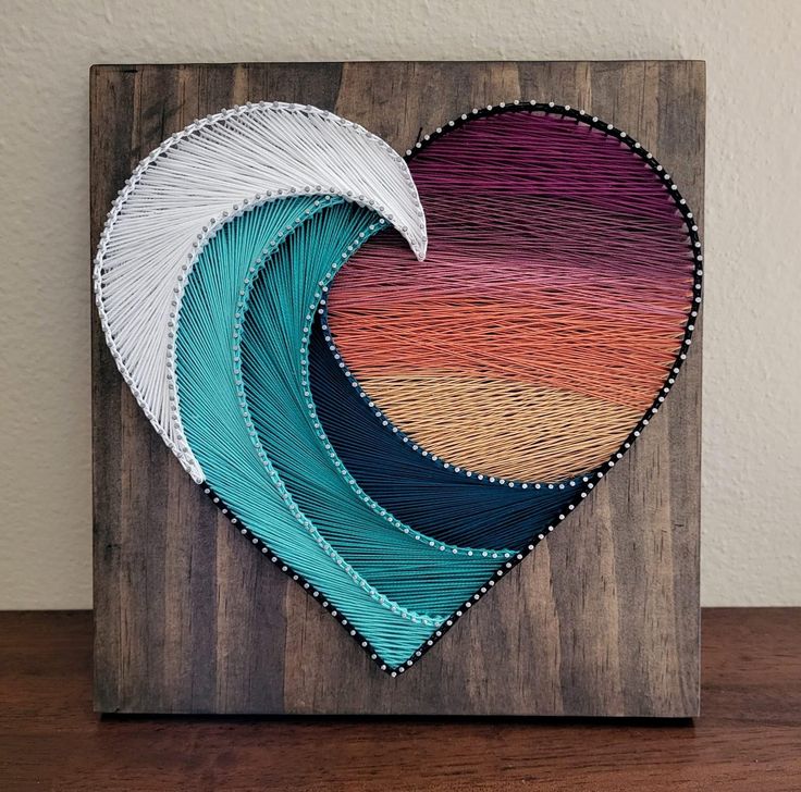 a heart shaped painting on top of a wooden board