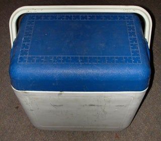 an old blue and white cooler sitting on the floor