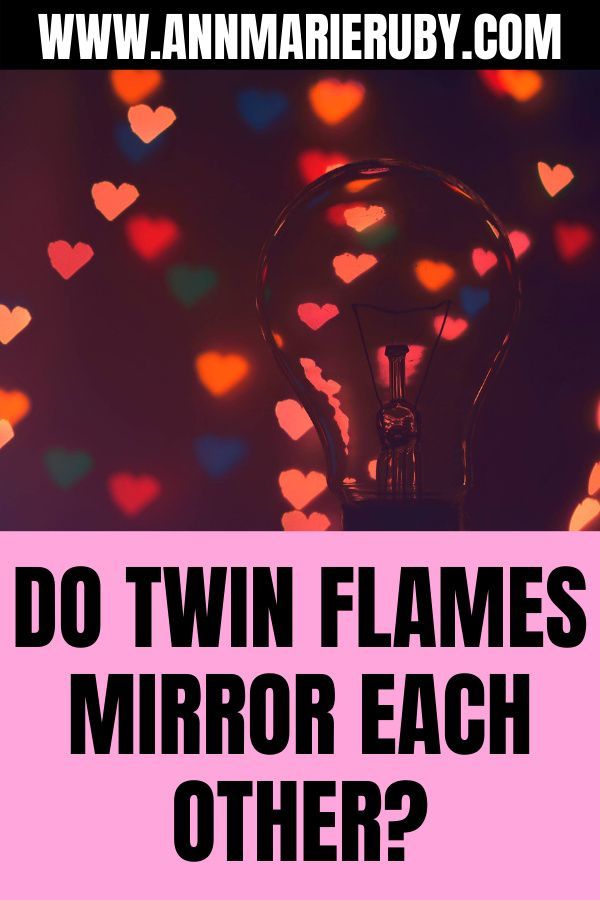 a light bulb sitting on top of a table next to a pink sign that says do twin flames mirror each other?