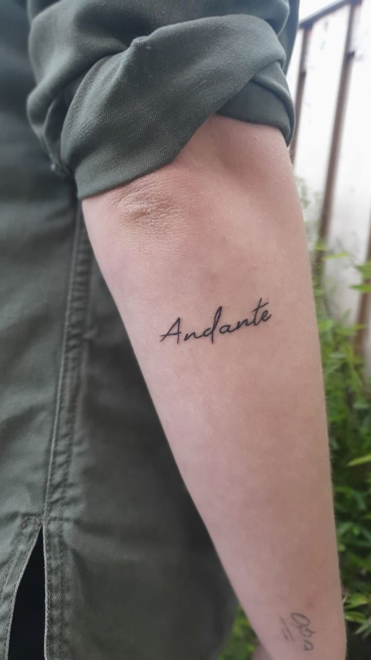 a person with a tattoo on their arm that says, andante in cursive writing